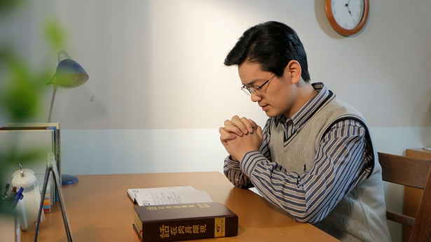 一個弟兄在桌前禱告