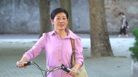 一個中年婦女推著車子看向前方