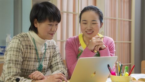 兩個姊妹正在電腦上討論問題